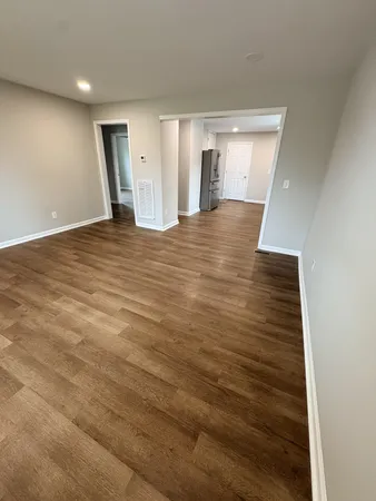 a view of an empty room with wooden floor