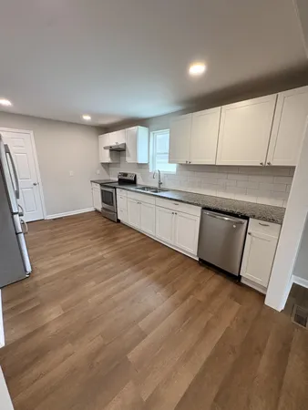 a kitchen with stainless steel appliances granite countertop a stove a sink and a refrigerator