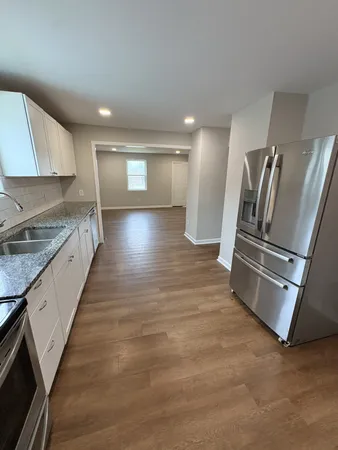 a view of a kitchen with a sink and refrigerator