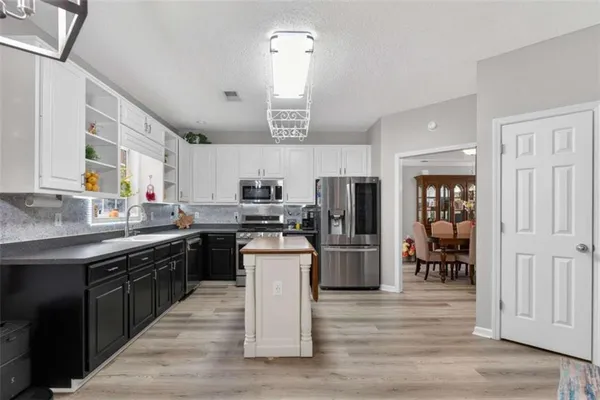a kitchen with stainless steel appliances granite countertop a stove top oven a refrigerator a sink and dishwasher