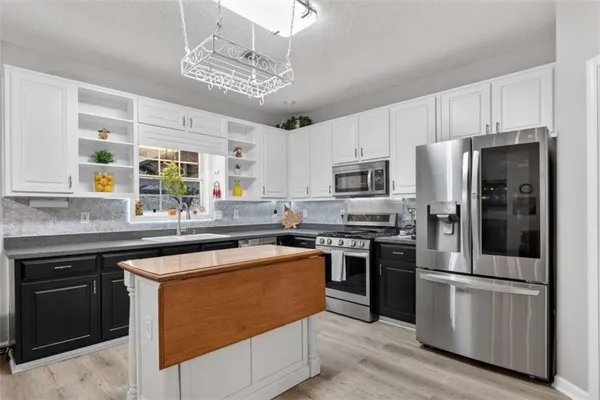 a kitchen with stainless steel appliances granite countertop a stove and a sink
