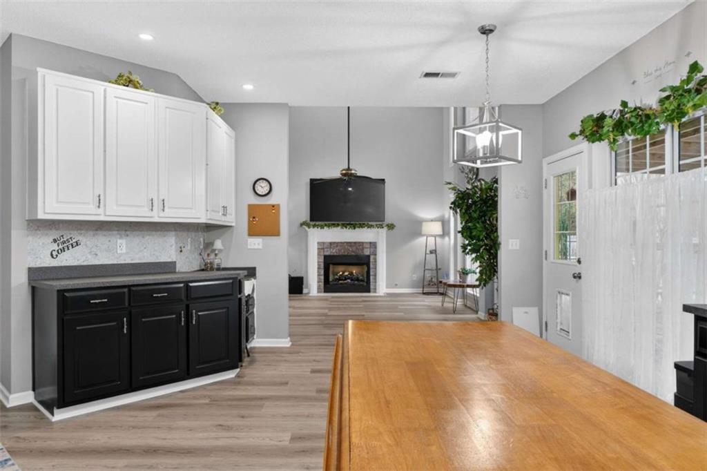 230 Gaelic Way Tyrone, GA 30290 - Photo 16 of 53 a large kitchen with a fireplace and wooden floor