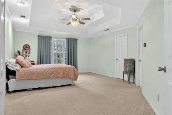 a spacious bedroom with a large bed and a chandelier