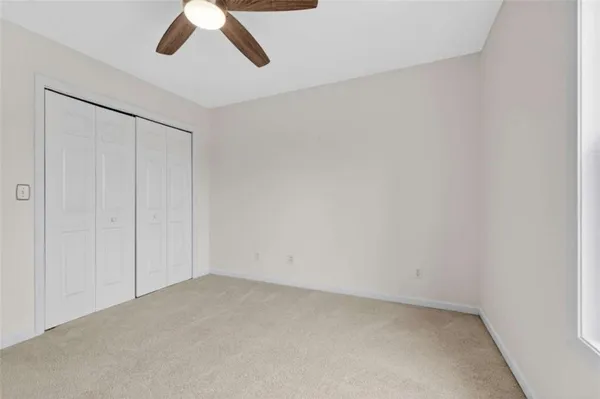 a view of an empty room with a window and kitchen