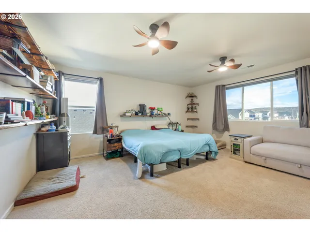 a spacious bedroom with a bed a couch and a large window