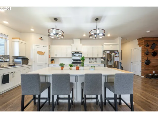 a kitchen with kitchen island a dining table and chairs