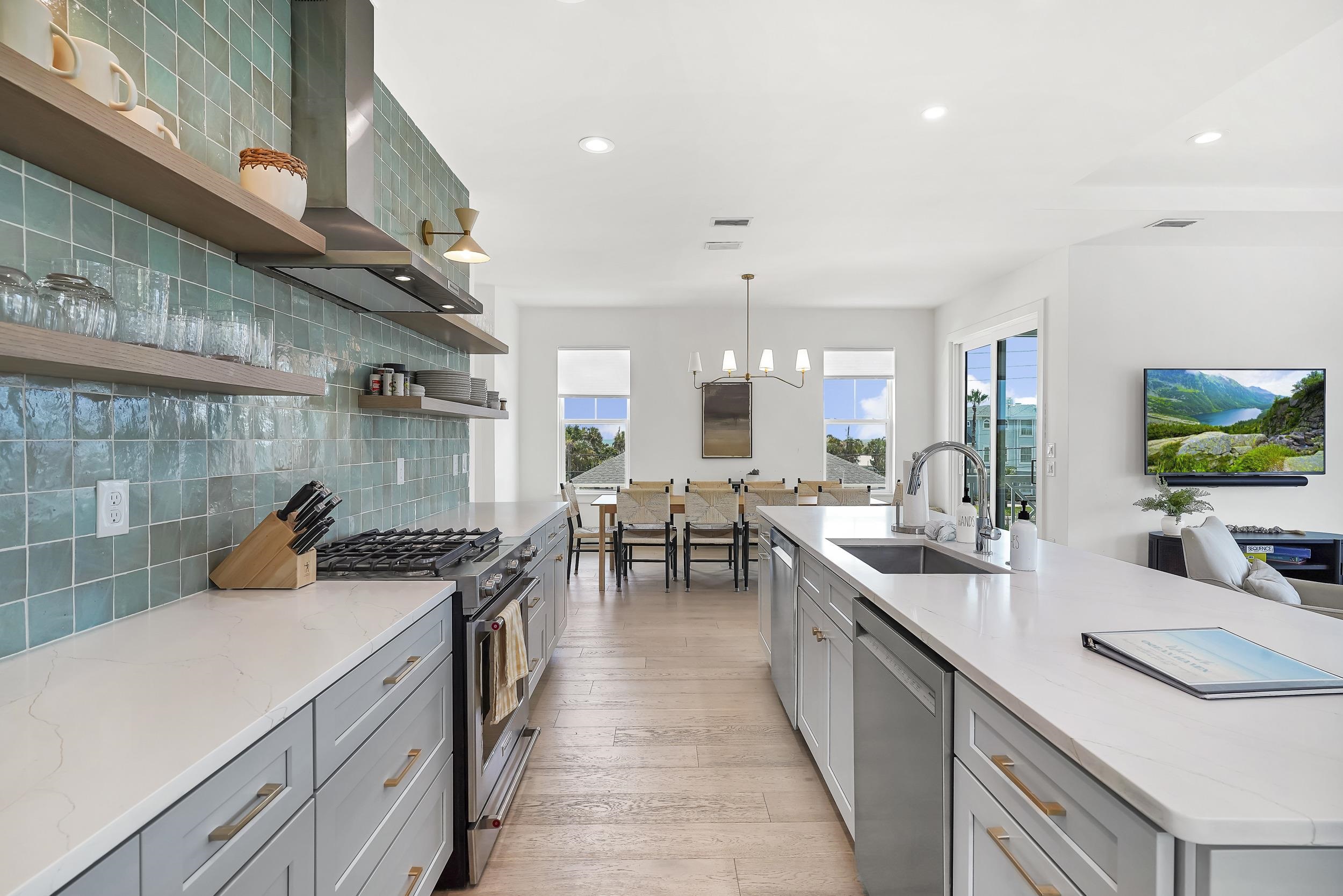 104 7th Street St. Augustine, FL 32080 - Photo 11 of 59 Kitchen with gray cabinets, stainless steel appliances, open shelves, backsplash, and light stone counters