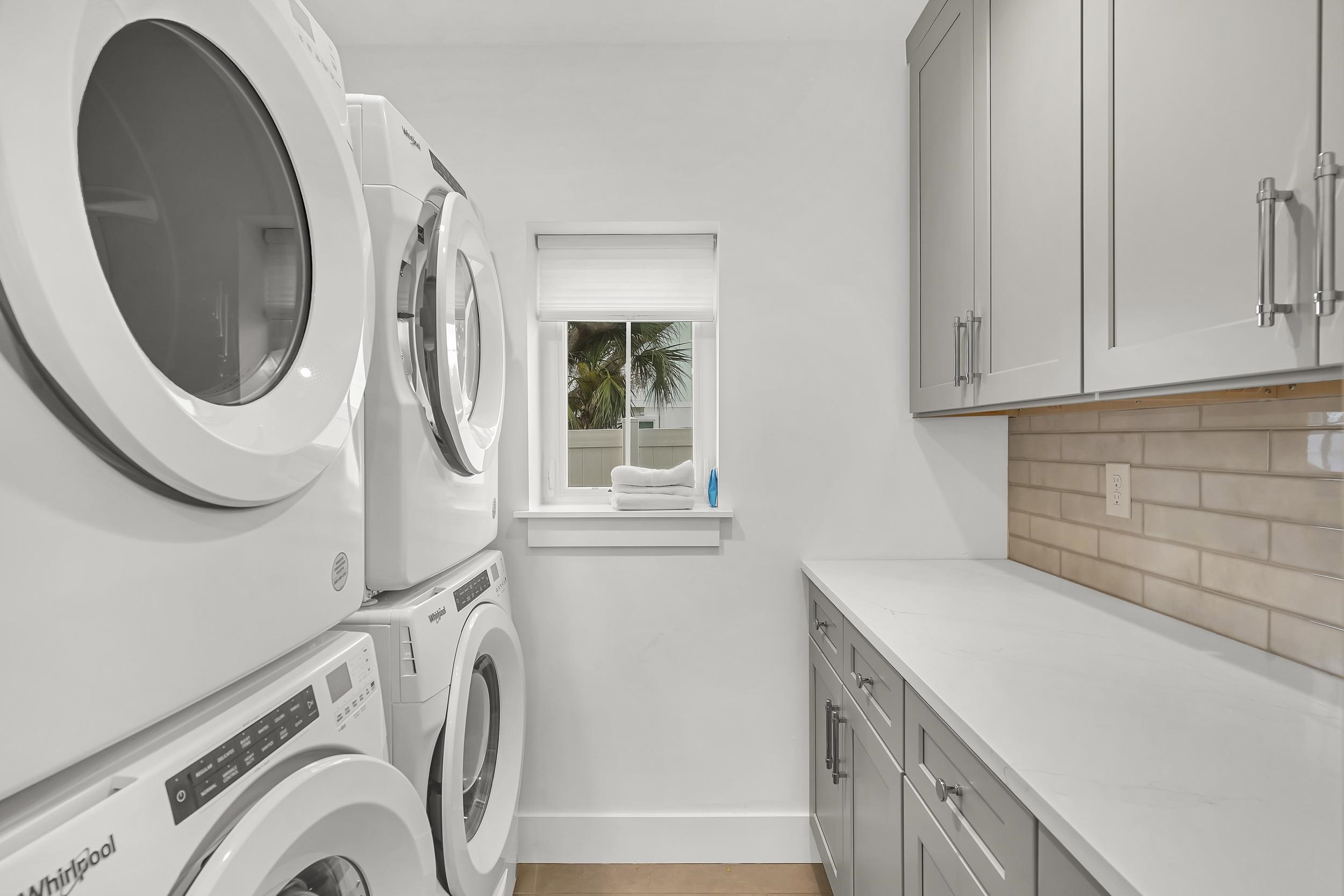 104 7th Street St. Augustine, FL 32080 - Photo 27 of 59 Laundry room featuring cabinet space and stacked washer and clothes dryer