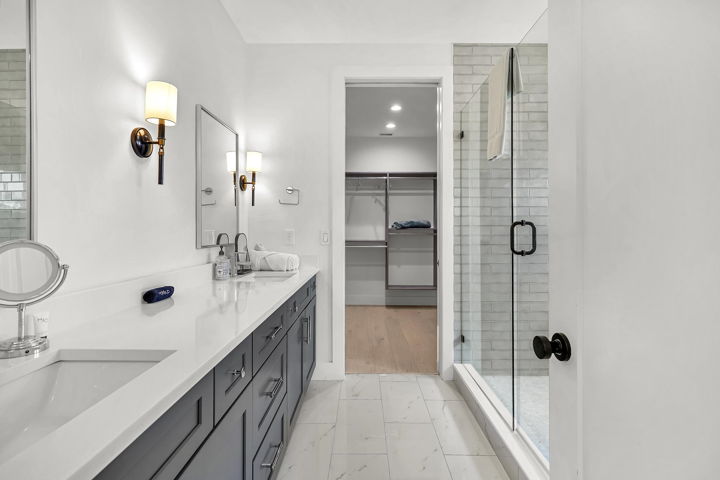 104 7th Street St. Augustine, FL 32080 - Photo 40 of 59 Full bathroom featuring double vanity, a stall shower, a walk in closet, light marble finish flooring, and recessed lighting