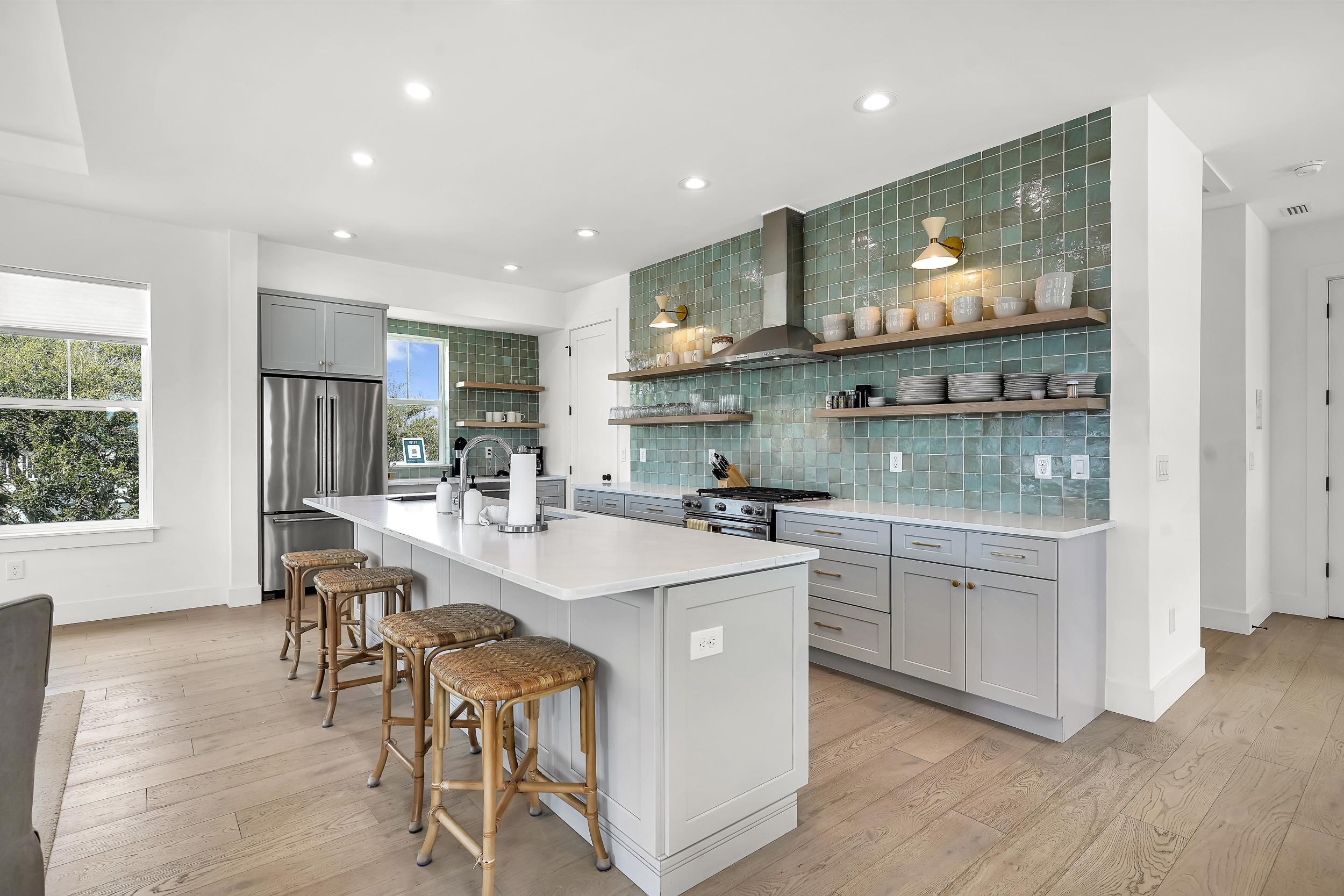 104 7th Street St. Augustine, FL 32080 - Photo 8 of 59 Kitchen with gray cabinets, high end appliances, a center island with sink, light wood-style flooring, and a breakfast bar