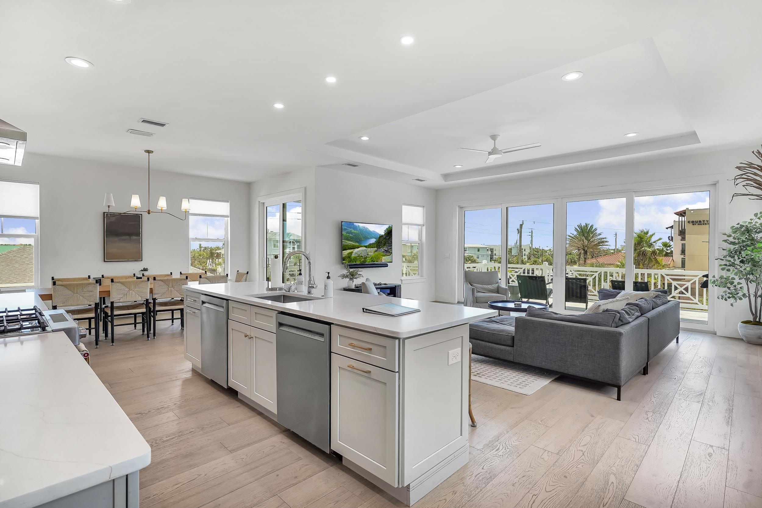 104 7th Street St. Augustine, FL 32080 - Photo 59 of 59 Kitchen with a kitchen island with sink, open floor plan, light wood-type flooring, a ceiling fan, and stainless steel appliances