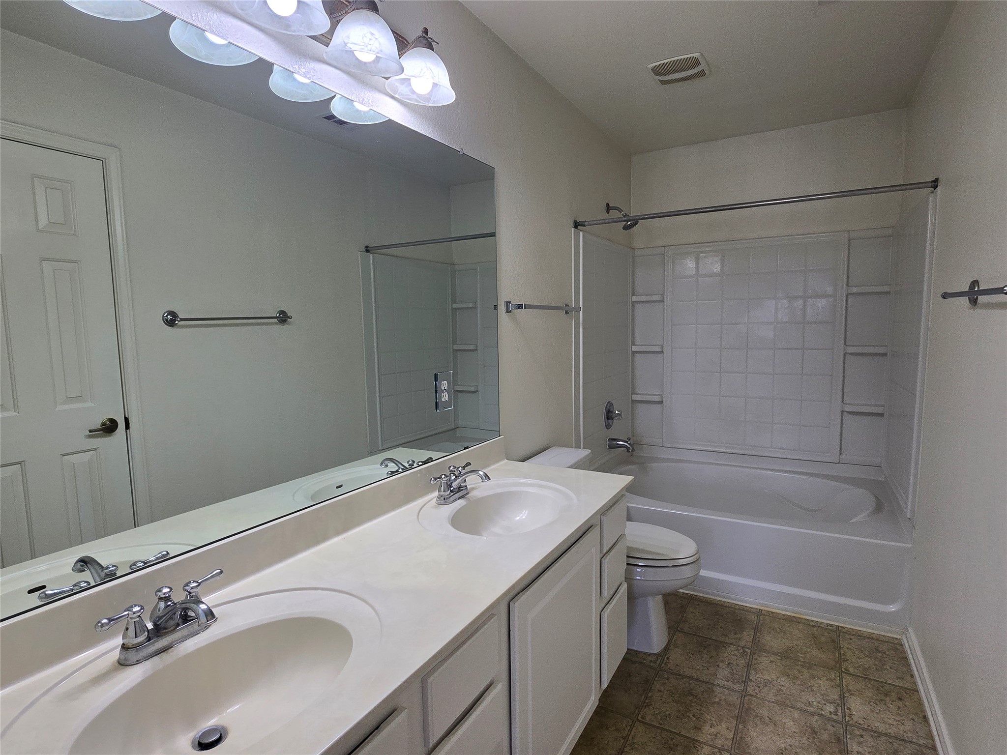 2021 Rim Rock Drive Leander, TX 78641 - Photo 6 of 14 A well-lit primary bath features a dual sink vanity with ample counter space and a classic tub-shower combination.