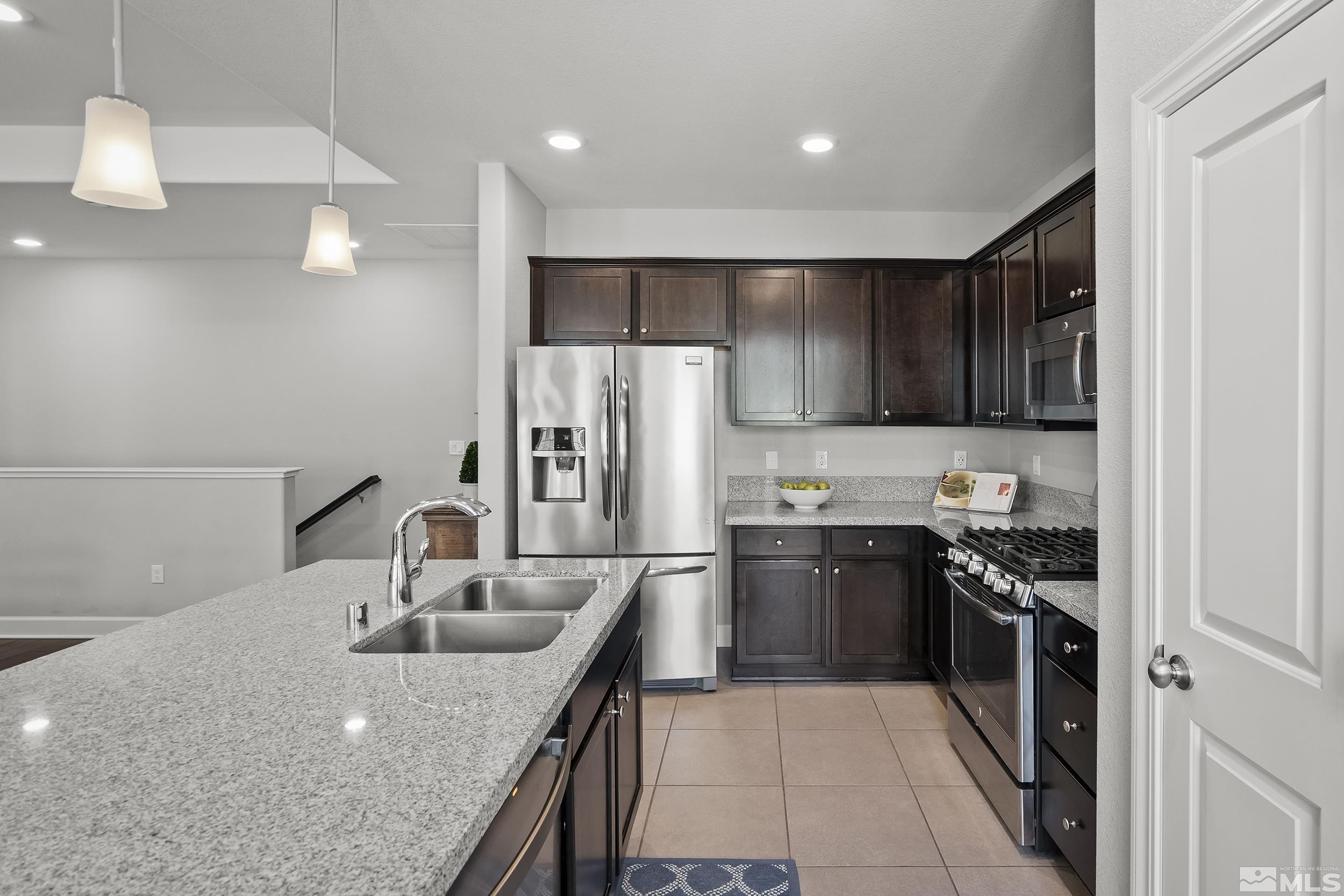 2037 Wind Ranch Road, Unit A Reno, NV 89521 - Photo 9 of 39 a kitchen with kitchen island a sink stainless steel appliances and cabinets