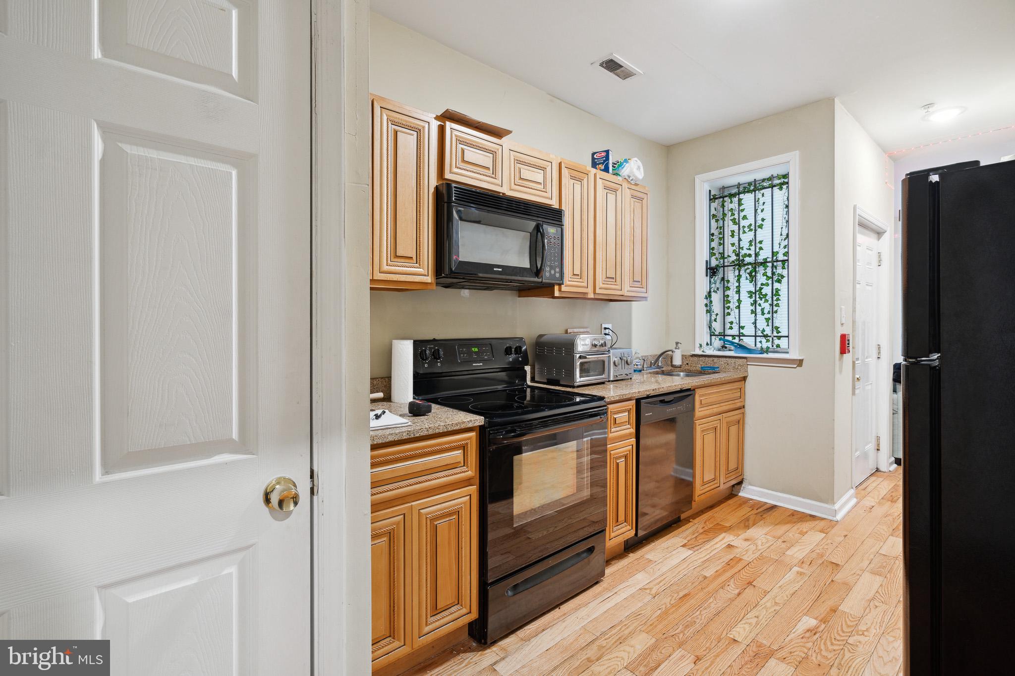 1611 North 17th Street, Unit 2 Philadelphia, PA 19121 - Photo 1 of 18 a kitchen with stainless steel appliances granite countertop a stove a sink and a refrigerator
