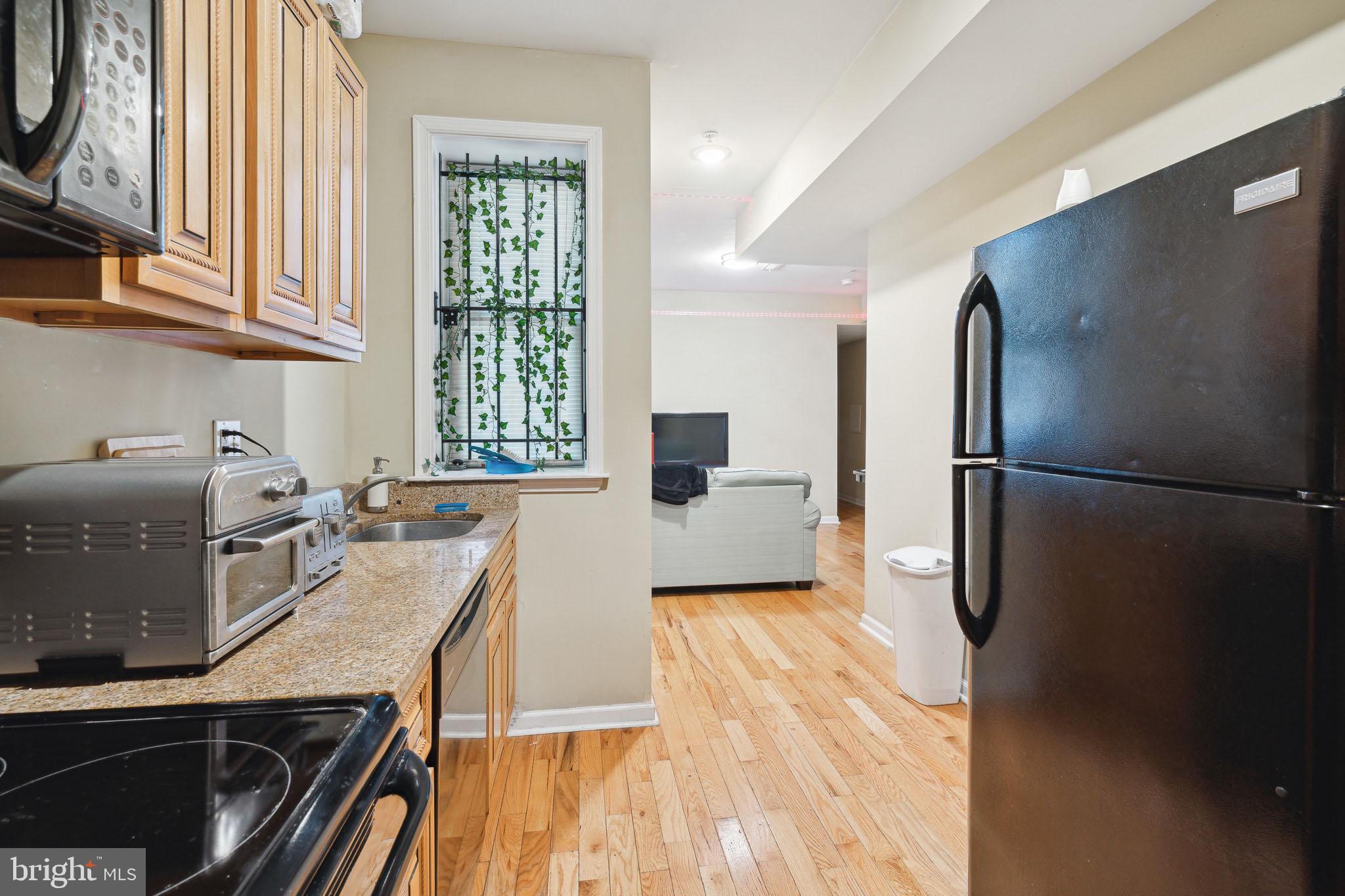 1611 North 17th Street, Unit 2 Philadelphia, PA 19121 - Photo 2 of 18 a kitchen with a refrigerator and a stove top oven