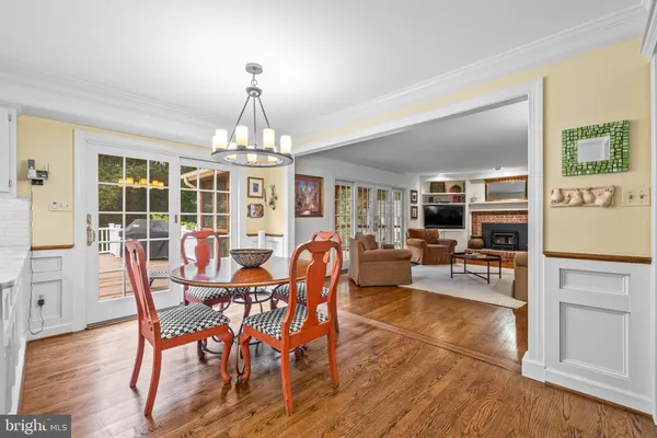 a dining room with furniture a chandelier and wooden floor