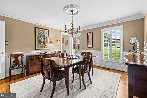 a view of a a dining room with furniture window and wooden floor