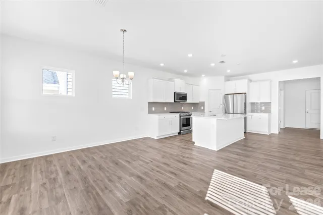 a kitchen with stainless steel appliances granite countertop a sink stove and microwave