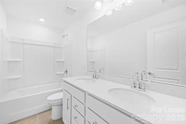 a bathroom with a granite countertop sink a toilet and bathtub