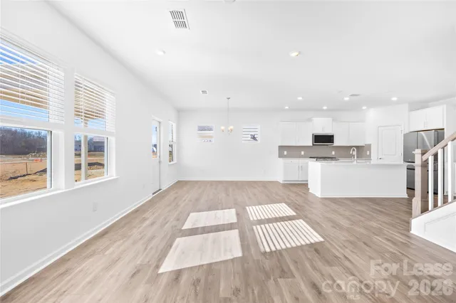 a large kitchen with cabinets wooden floor and stainless steel appliances