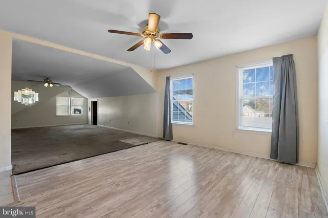 a view of a livingroom with a window and wooden floor