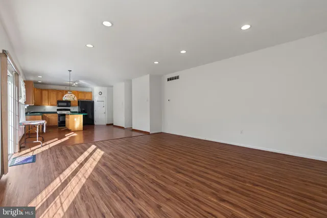 a view of a big room with wooden floor and windows