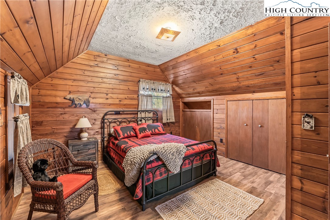 231 Deer Oaks Road Deep Gap, NC 28618 - Photo 20 of 44 a bedroom with a bed and wooden floor