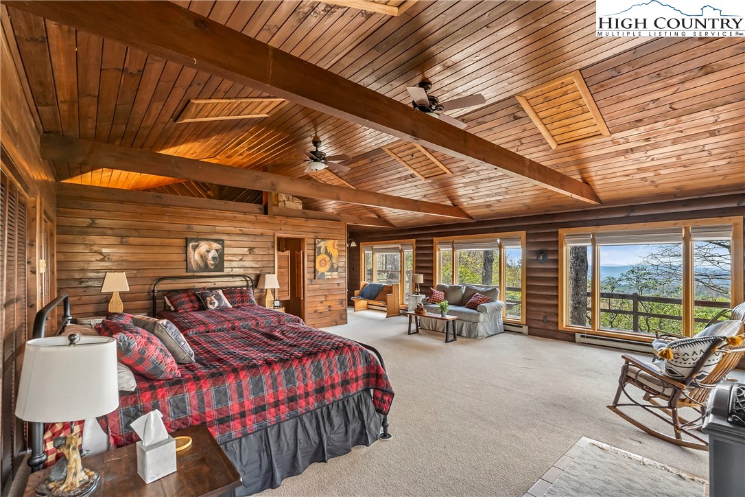 231 Deer Oaks Road Deep Gap, NC 28618 - Photo 25 of 44 a bedroom with furniture and large windows