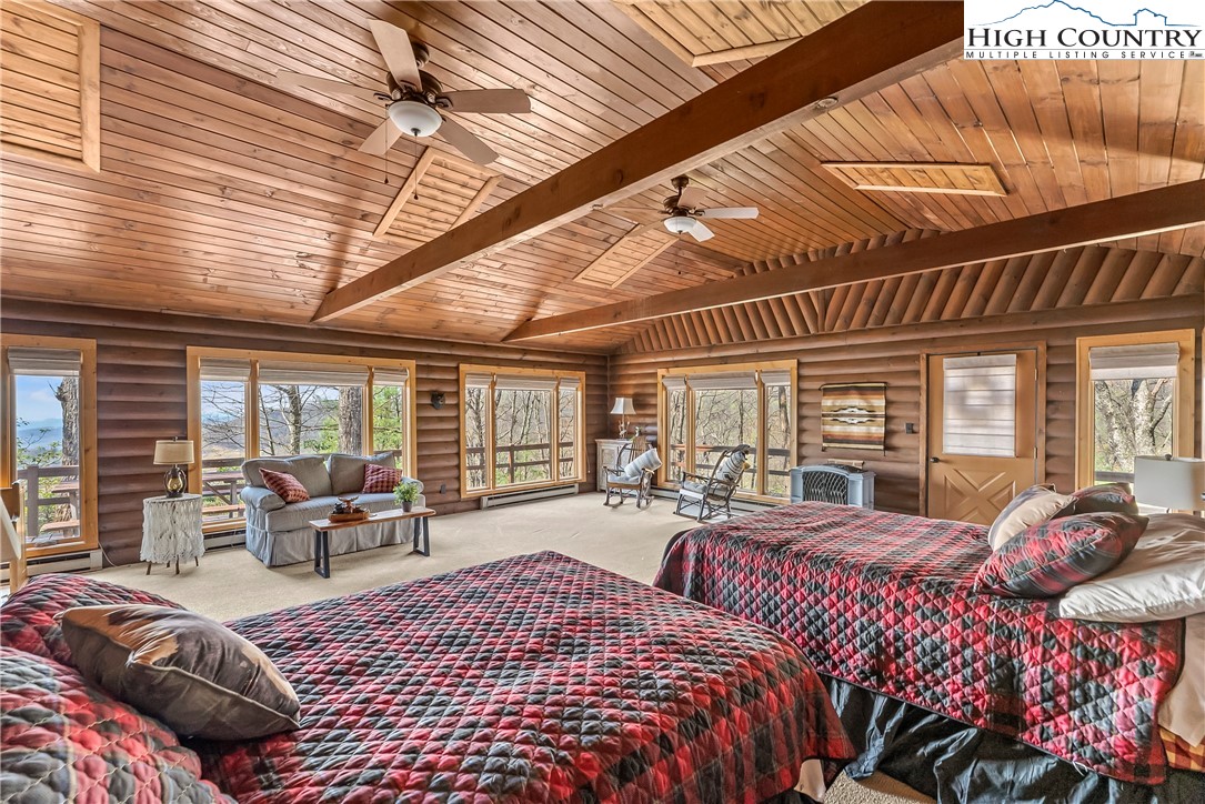 231 Deer Oaks Road Deep Gap, NC 28618 - Photo 26 of 44 a bedroom with furniture beds and large windows