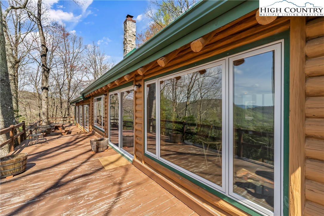 231 Deer Oaks Road Deep Gap, NC 28618 - Photo 31 of 44 a porch with a table and chairs next to a yard