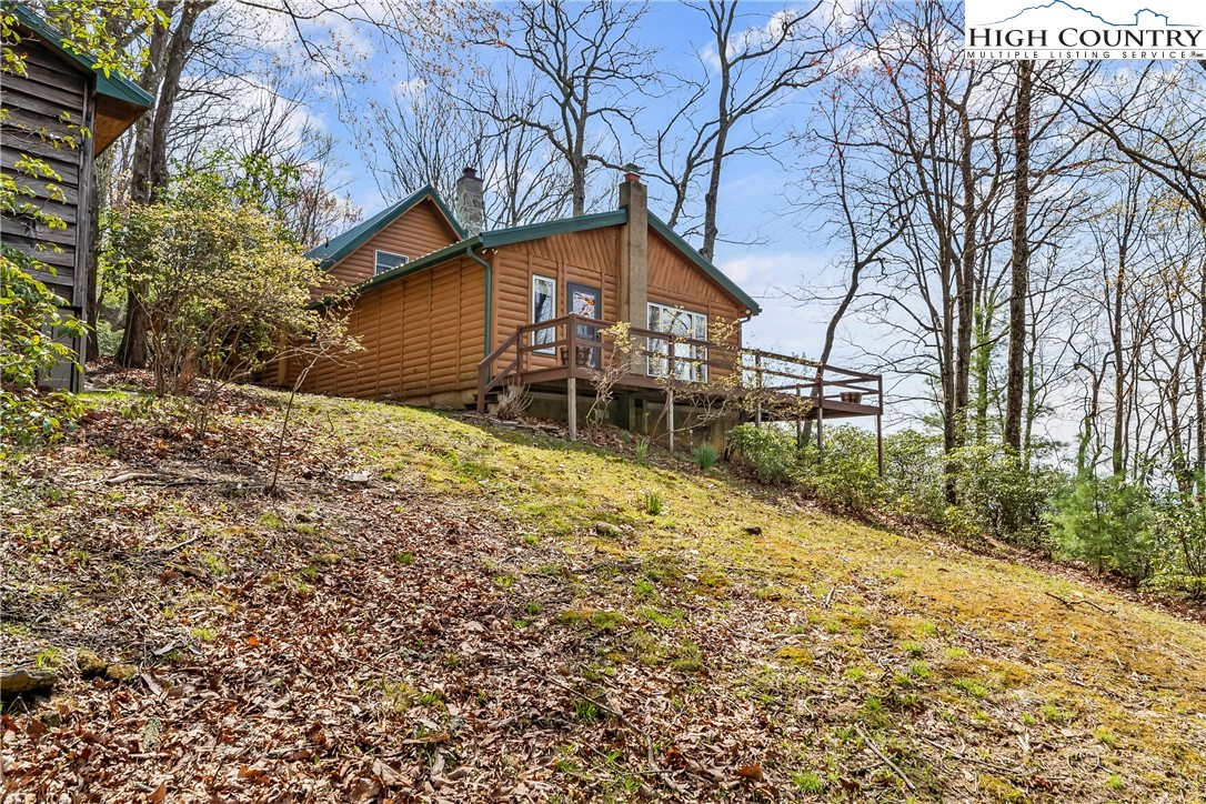 231 Deer Oaks Road Deep Gap, NC 28618 - Photo 34 of 44 a backyard of a house with large trees and barbeque oven