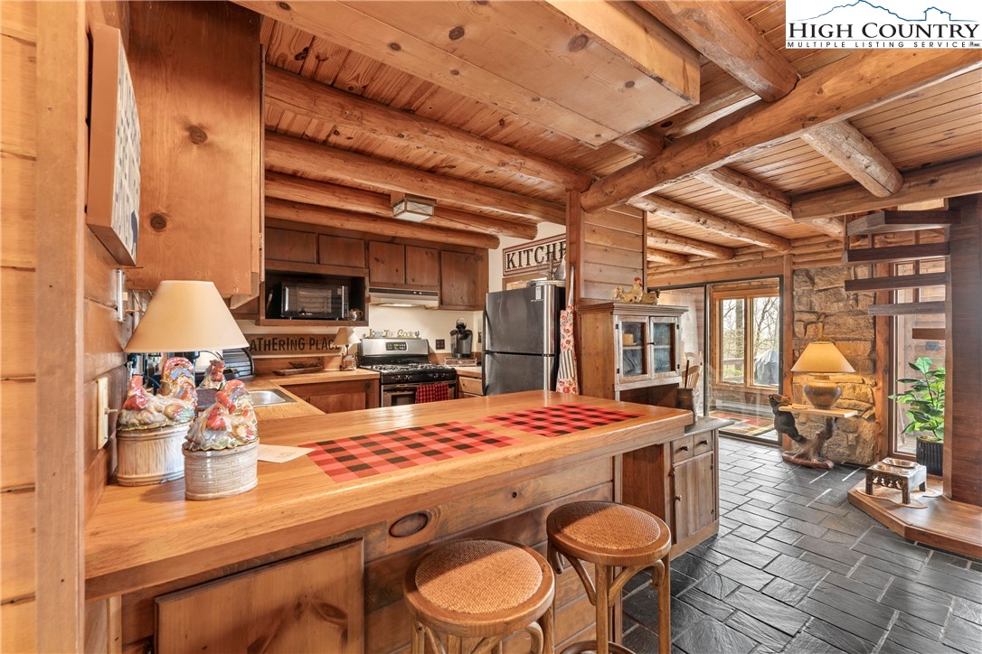 231 Deer Oaks Road Deep Gap, NC 28618 - Photo 8 of 44 a kitchen with a table chairs stove and granite counter top