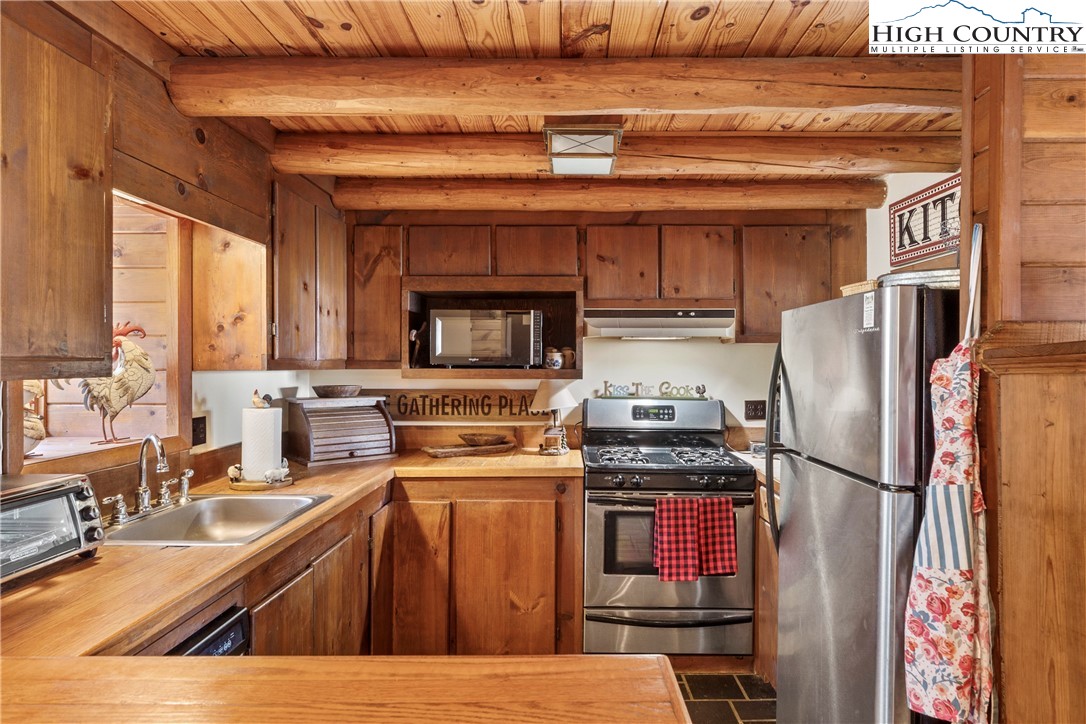 231 Deer Oaks Road Deep Gap, NC 28618 - Photo 9 of 44 a kitchen with a refrigerator wooden floor and a view of living room