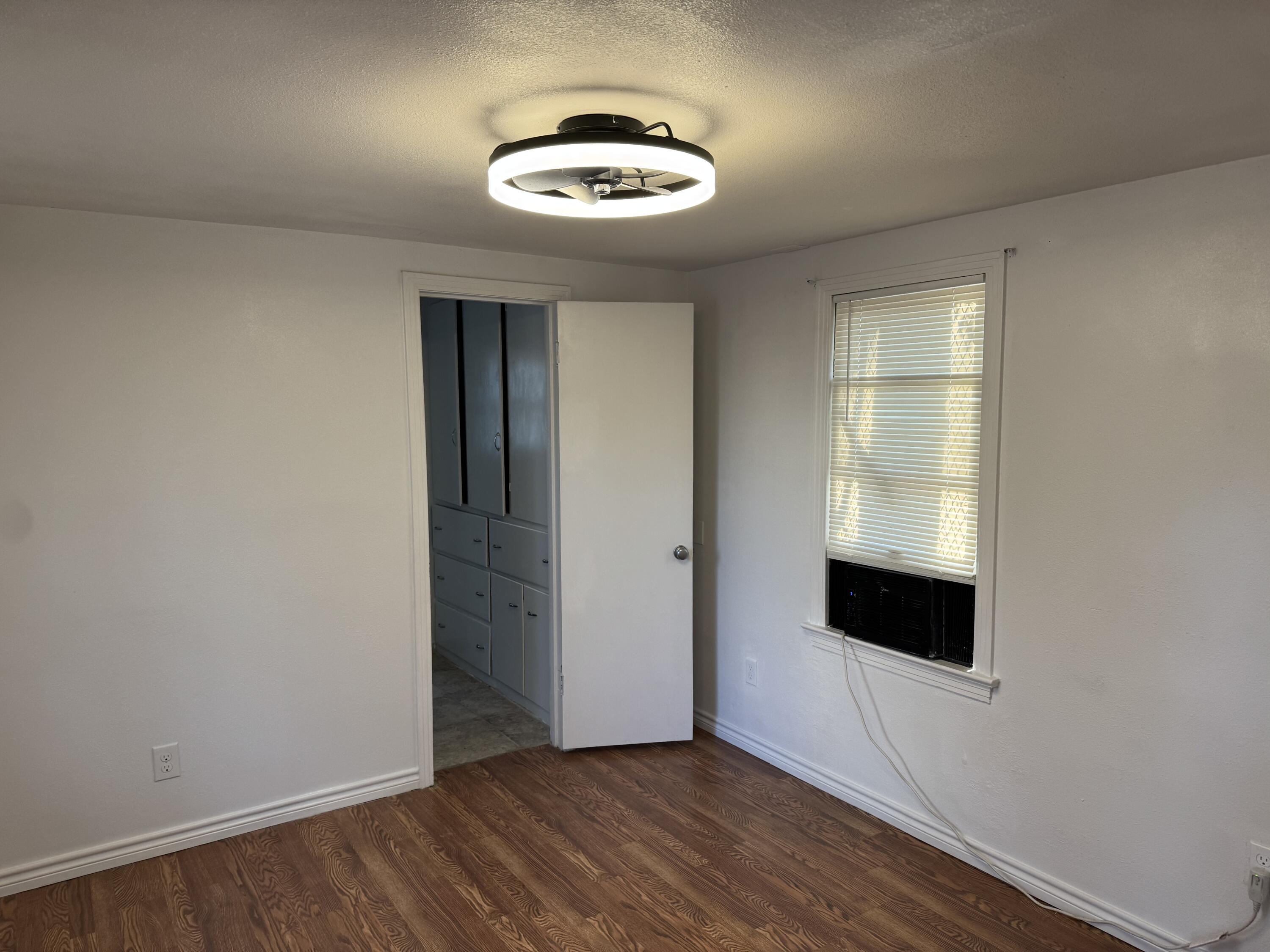 2708 20th Street, Unit REAR Lubbock, TX 79410 - Photo 3 of 10 an empty room with wooden floor and windows