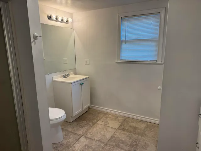 a bathroom with a sink a toilet and a mirror