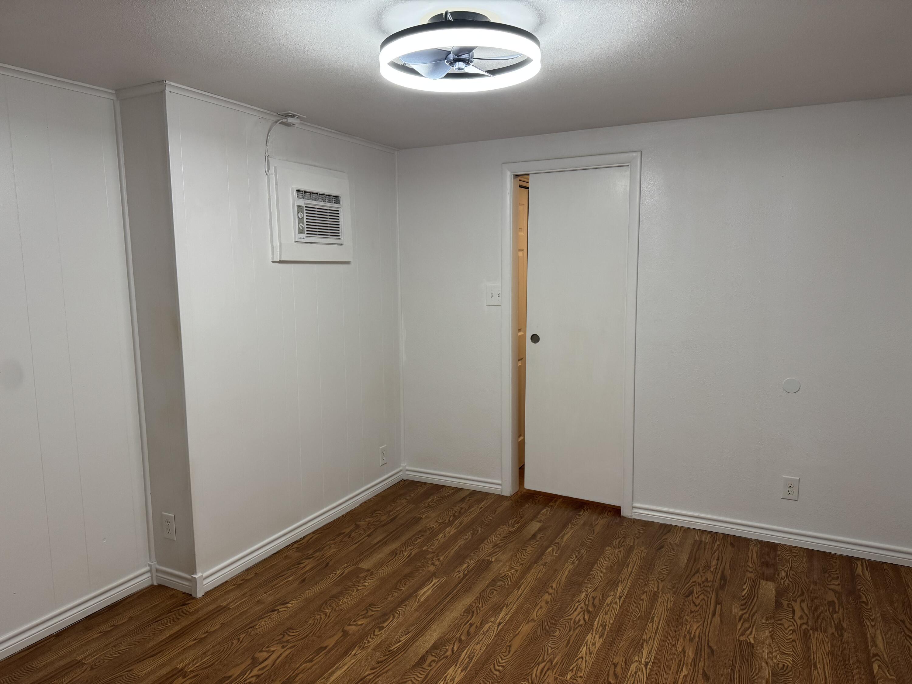 2708 20th Street, Unit REAR Lubbock, TX 79410 - Photo 6 of 10 an empty room with wooden floor and windows
