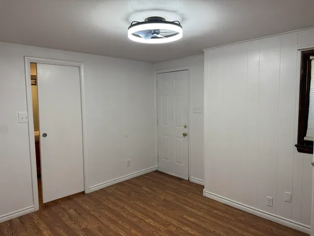 an empty room with wooden floor and a window