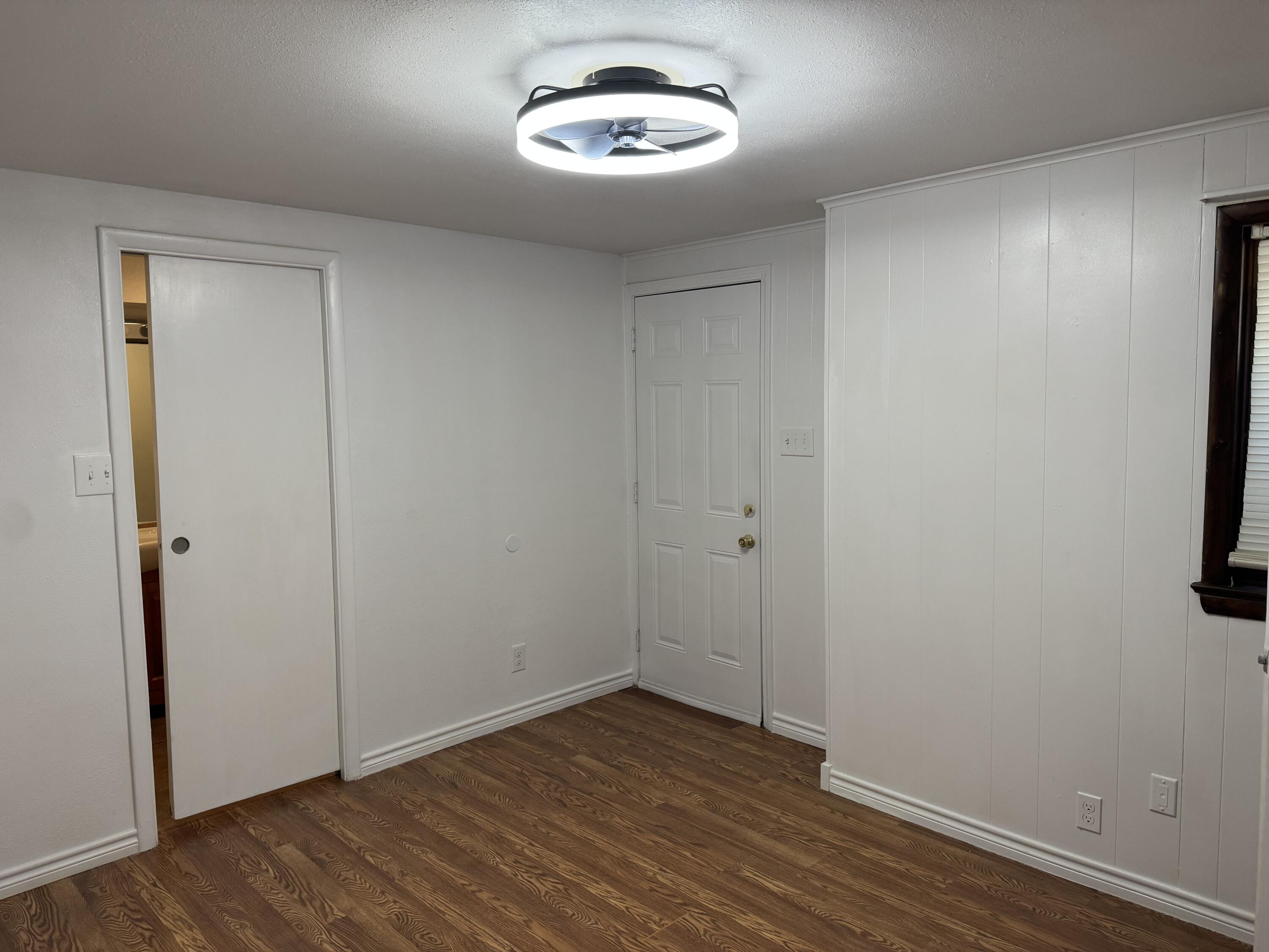 2708 20th Street, Unit REAR Lubbock, TX 79410 - Photo 7 of 10 an empty room with wooden floor and a window