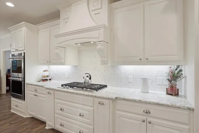 a kitchen with granite countertop white cabinets and white appliances