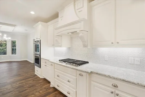 a kitchen with granite countertop a sink cabinets and stainless steel appliances