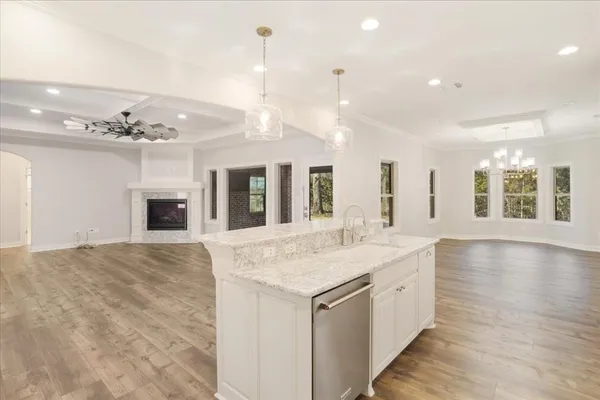 a hall with kitchen island a sink granite counter tops and a fireplace