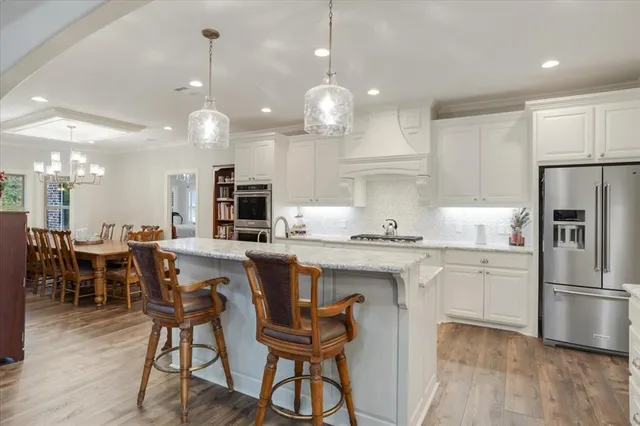 a kitchen with kitchen island granite countertop a sink a center island and stainless steel appliances