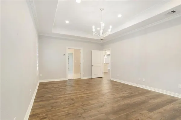 wooden floor in an empty room with a chandelier