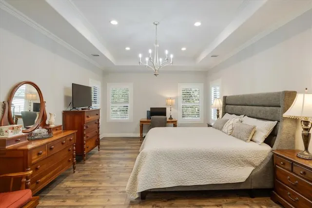 a spacious bedroom with a bed and a flat screen tv