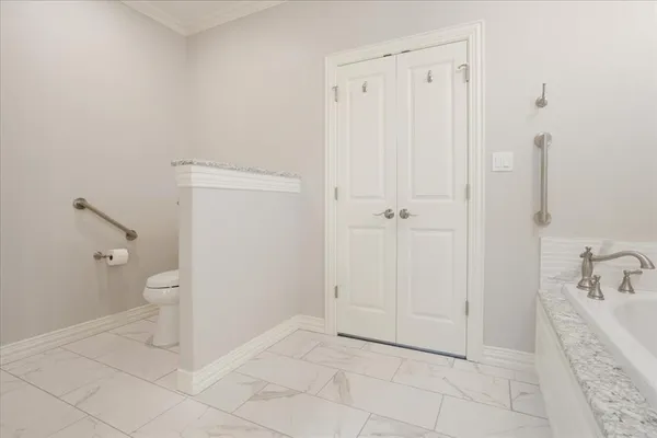 a spacious bathroom with a granite countertop toilet and a sink