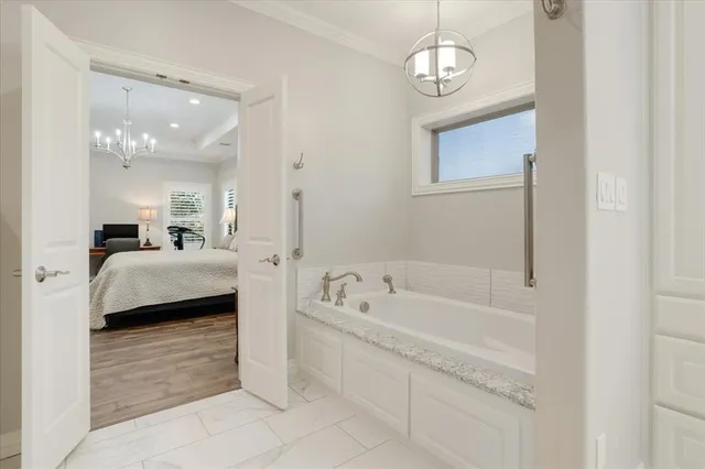 a en suite spacious bathroom with a granite countertop tub a double vanity sink and mirror