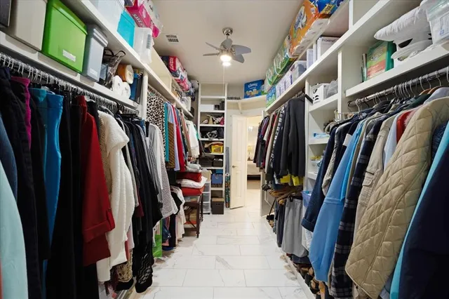 a view of walk in closet with clothes and shoes