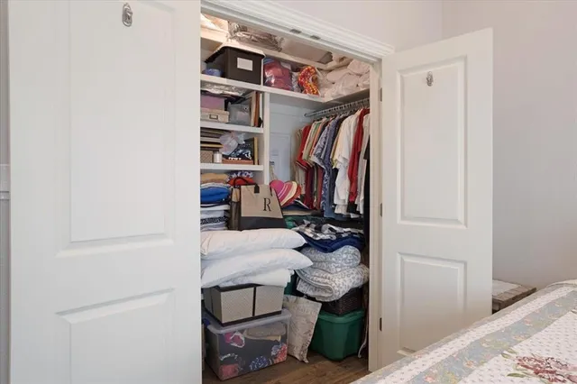 a view of walk in closet with clothes and shoes