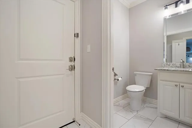 a bathroom with a granite countertop toilet and a sink
