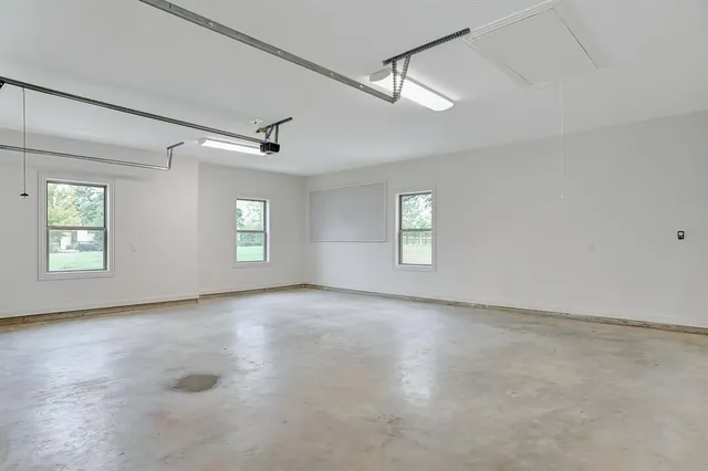 an empty room with windows and ceiling fan